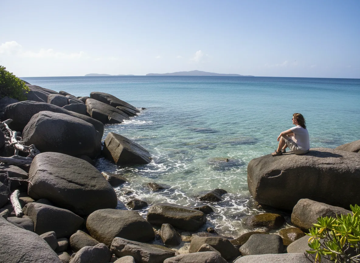 A quiet shoreline in St. Croix with a traveler pausing to look out at the sea.